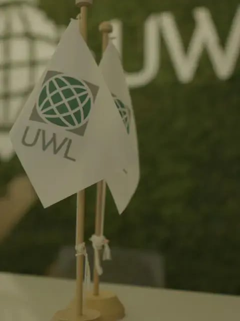 UWL flag on the green wall at the Itajaí office reception